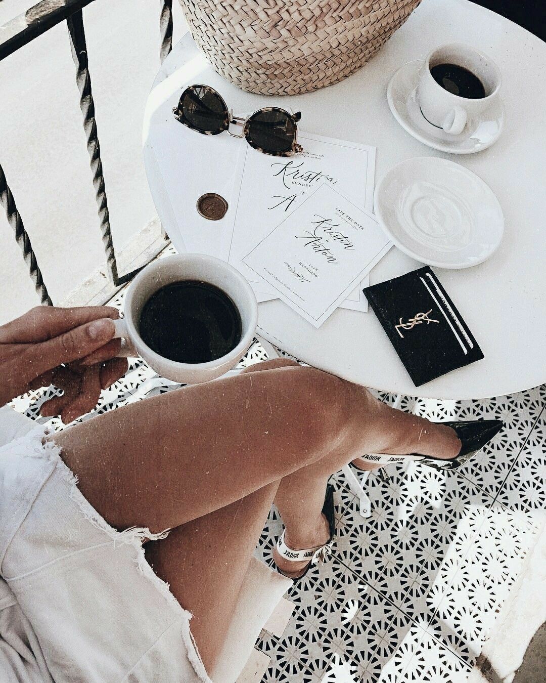 woman with chanel shoes and save the dates at cafe having coffee