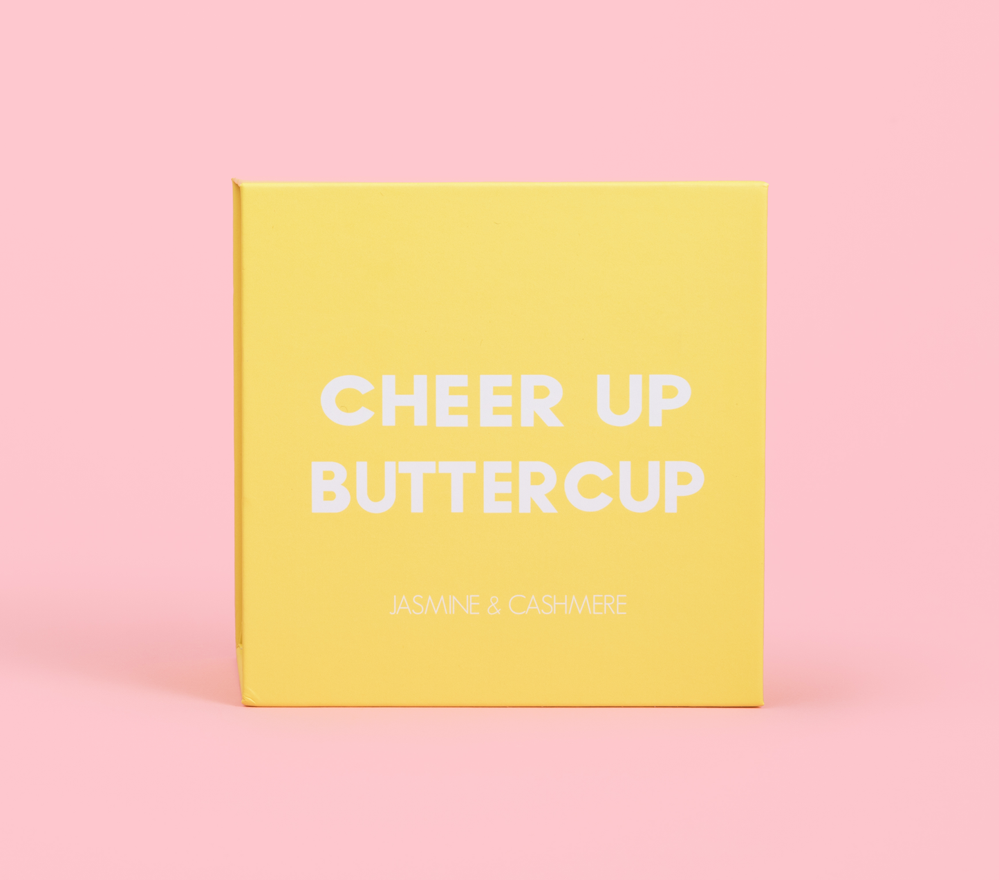 yellow candle gift box that says Cheer Up Buttercup placed on pink background