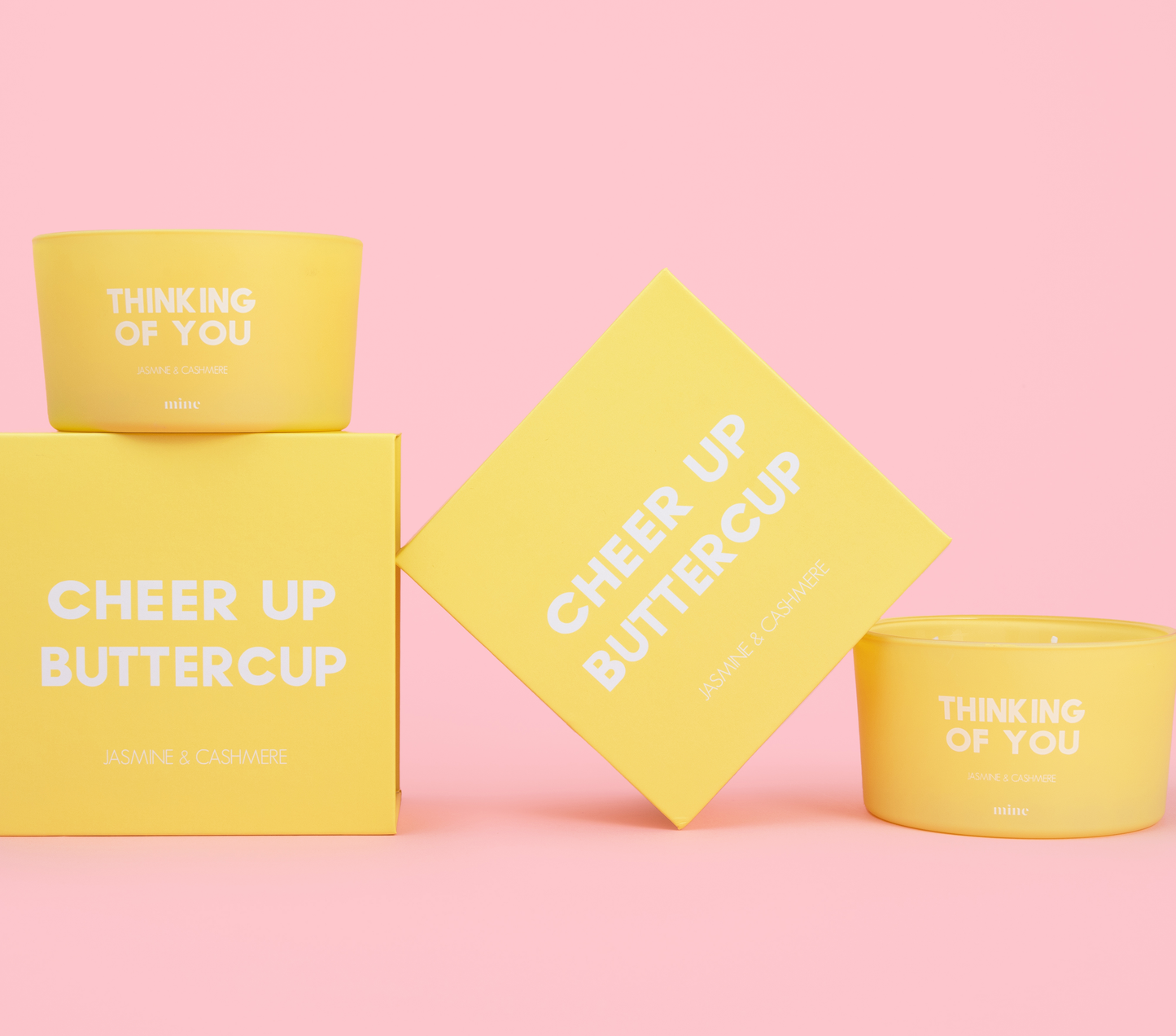 two yellow candles with yellow gift boxes on pink background with message cheer up buttercup and thinking of you