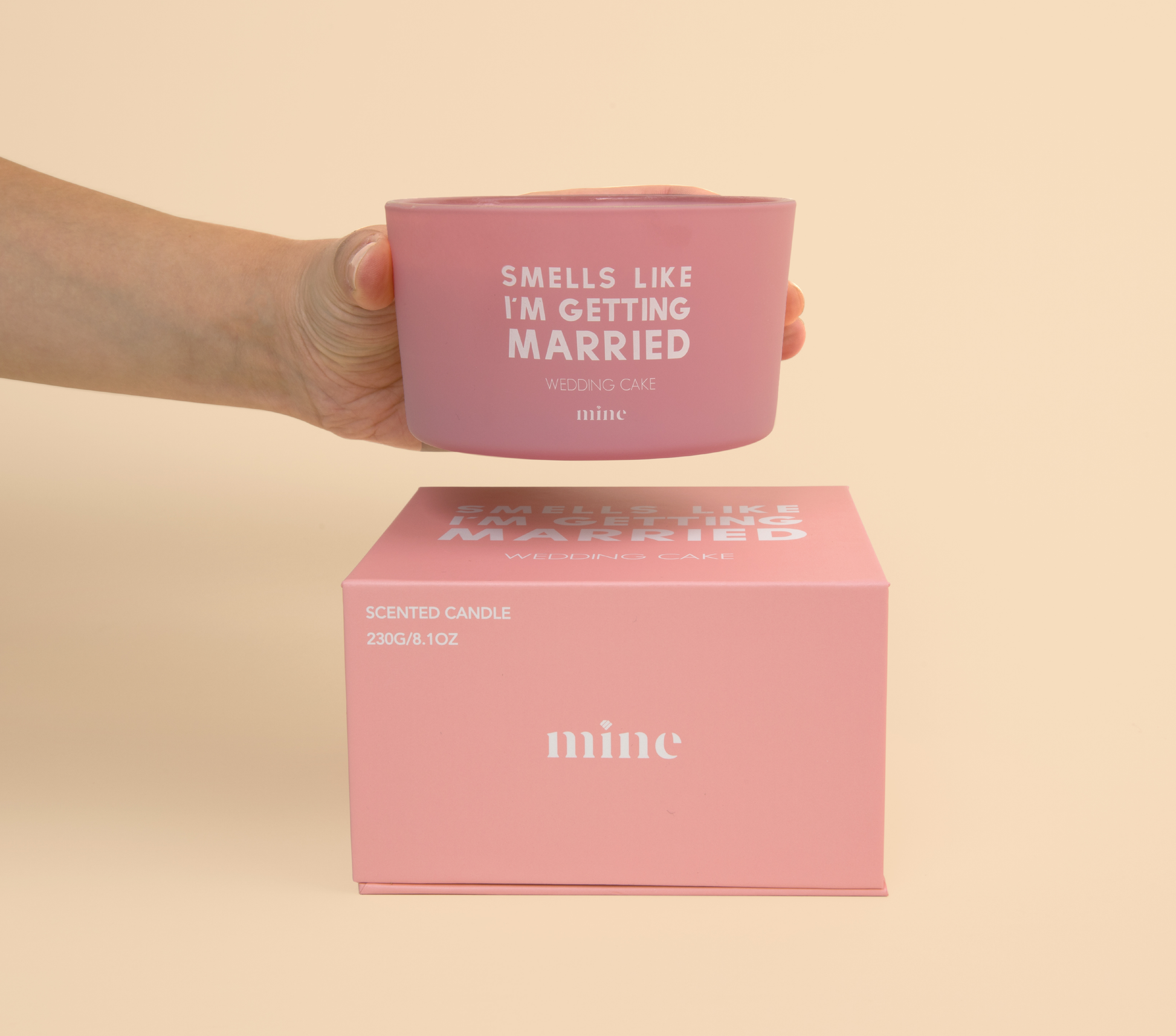 Wedding Cake Candle - The Mine Company - Smells Like I'm Getting Married - Pink Candle being held above gift box