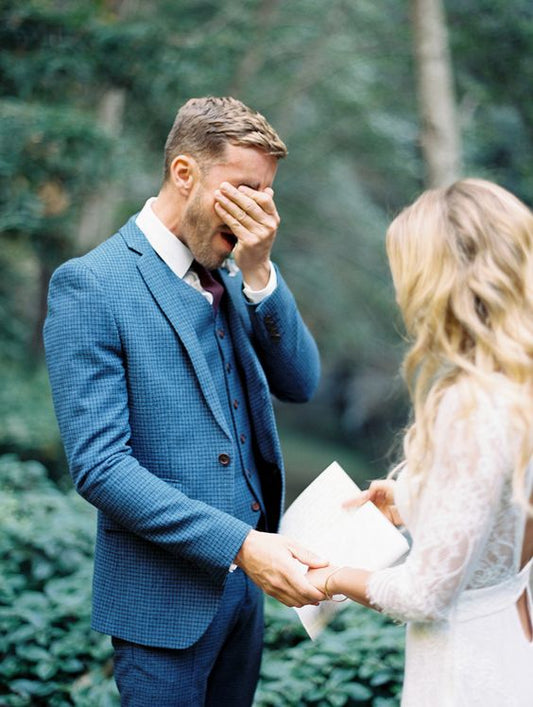 groom crying holding brides hand