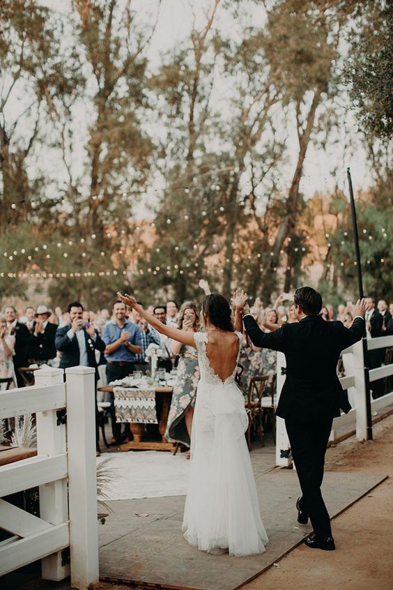 bride and groom making grand entrance to guests at outdoor wedding